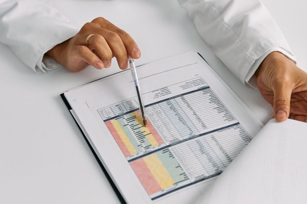 Hands pointing a pen at a colour-coded data chart