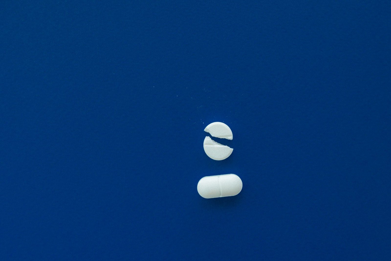 A whole and a split white tablet on a blue background