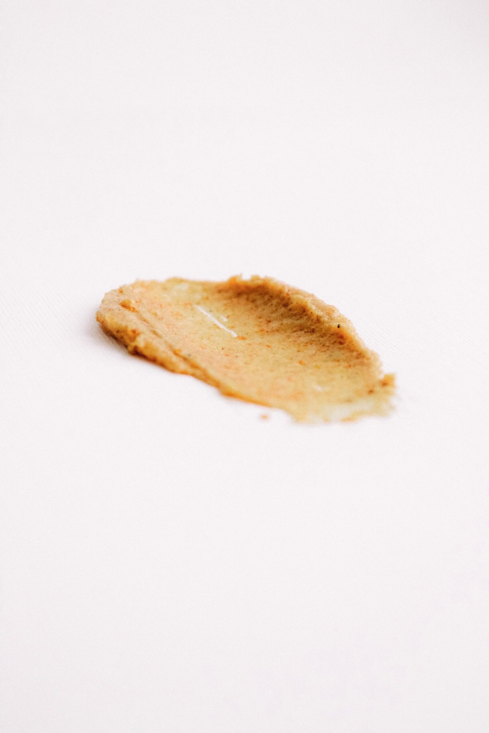 Swatch of a grainy exfoliating face scrub on white