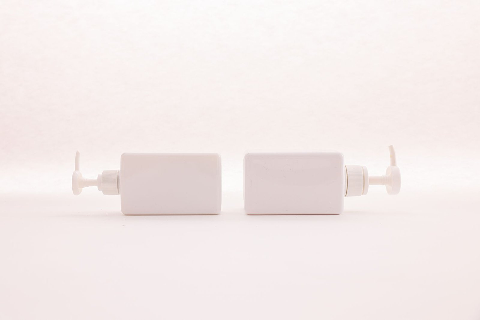 Two white pump bottles on a clean white background