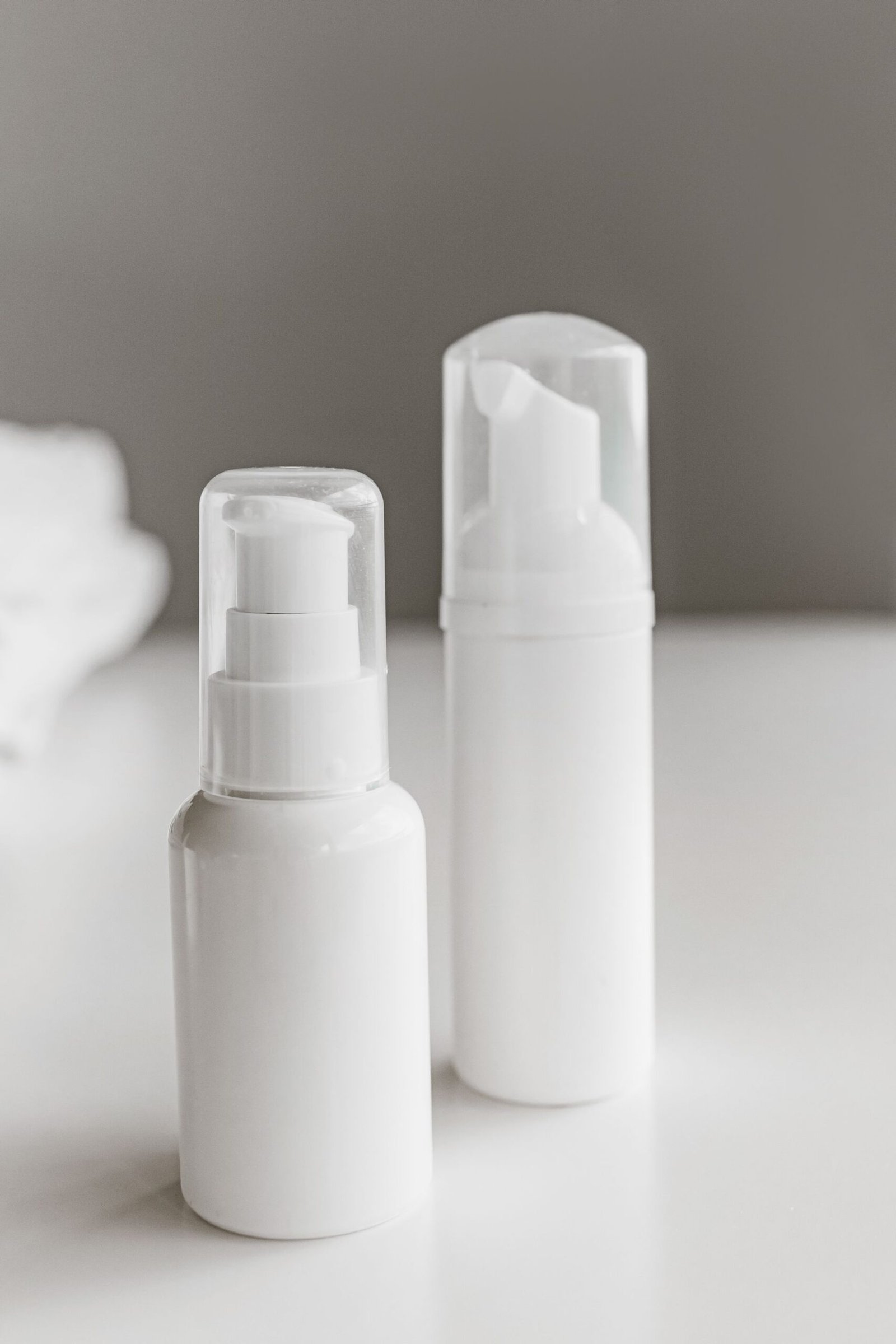 Two white pump bottles on a white surface