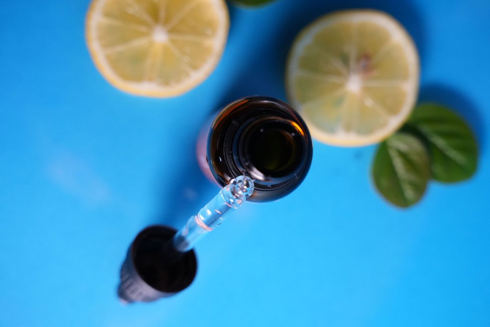 Dropper bottle with lemon slices on a blue background
