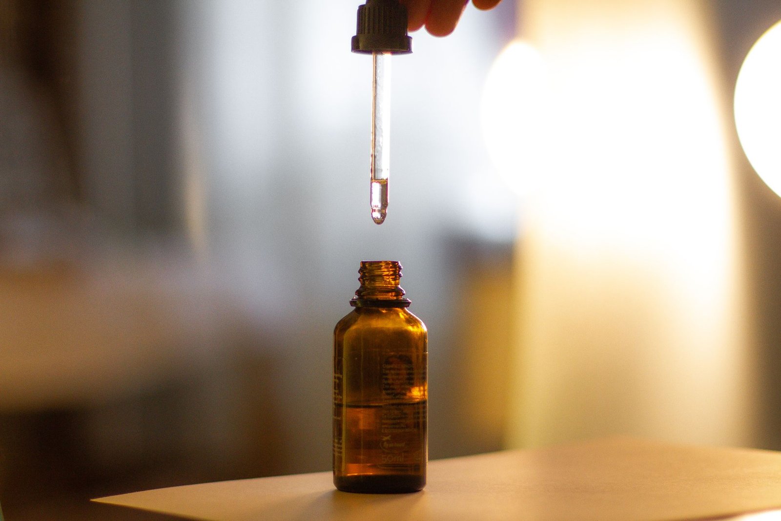 Serum dropper held above an amber glass bottle