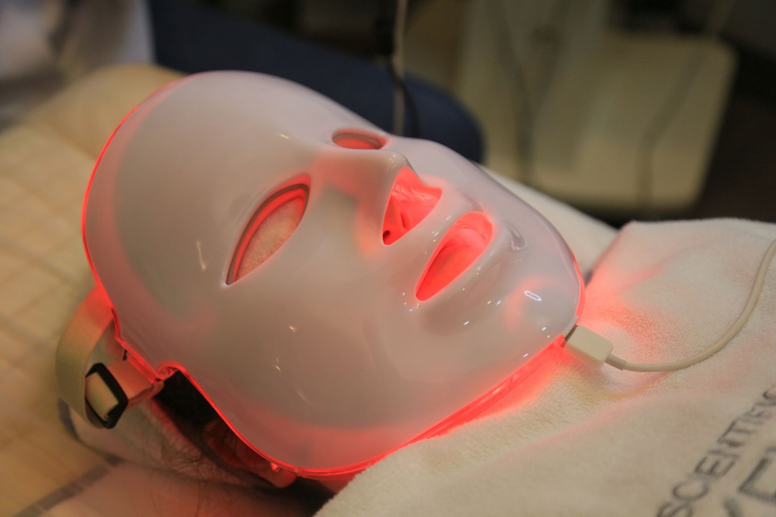 LED light therapy face mask glowing red during a treatment
