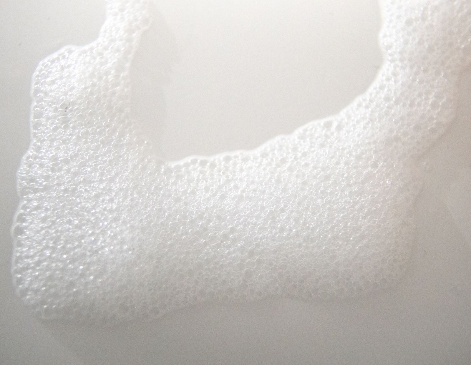 Close-up of white foam bubbles on a smooth surface