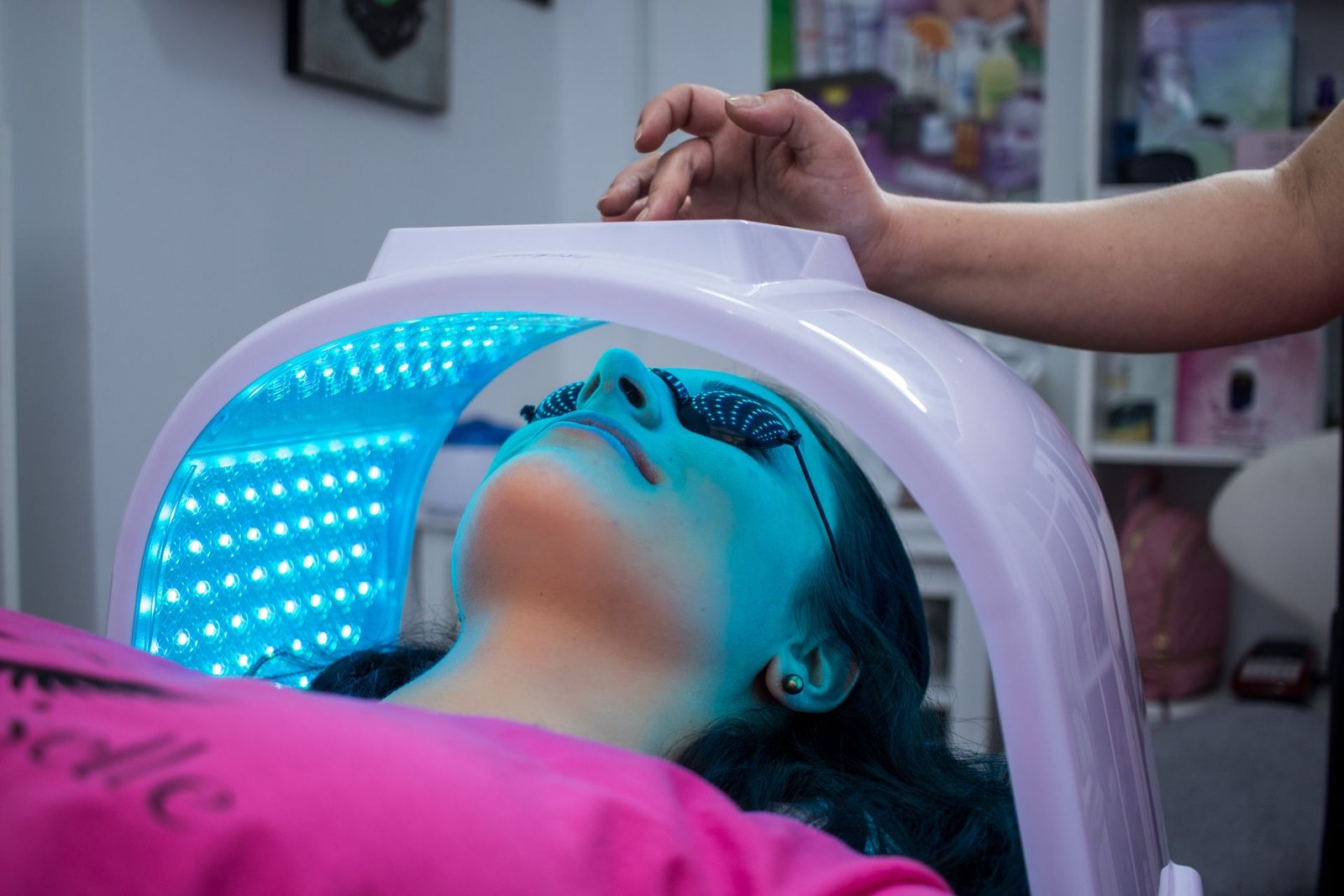 Blue LED light therapy panel over a face during a clinic session